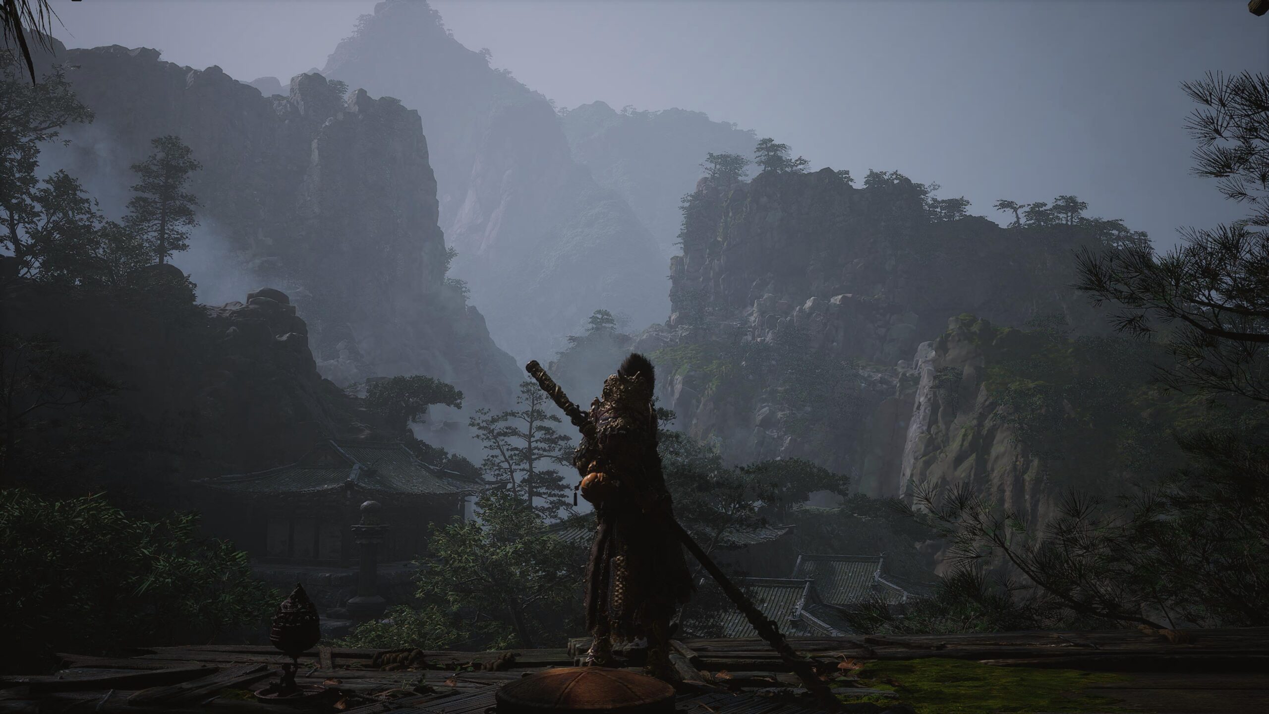 The Destined One in Black Myth: Wukong standing at an invisible barrier, overlooking temple roofs and mountains that cannot be reached