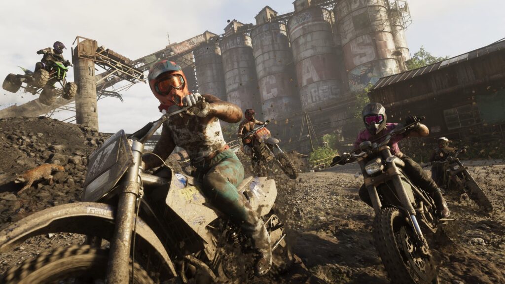 Dirt bikers race through mud beneath an industrial structure in Mount Kalaga National Park. Image: Rockstar Games.