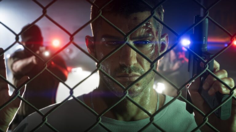 Jason peers through a chain-link fence lit by blue and red police lights. Image: Rockstar Games.