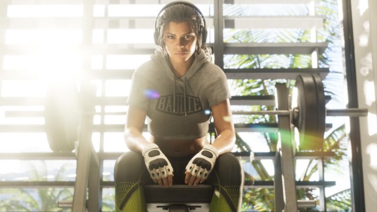 Lucia in headphones and fingerless gloves sits on a gym bench. Image: Rockstar Games.