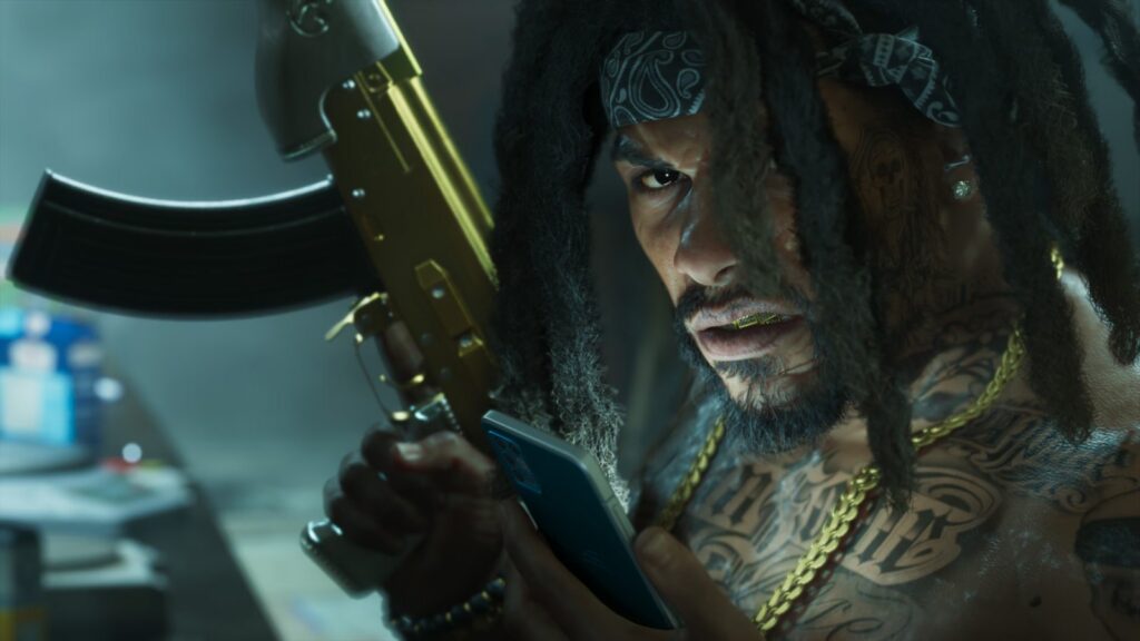 Raymond of the S4S gang, dreads and gold chains, holds a gold-plated rifle and checks his phone in the drug lab from An Extended Look. Image: Rockstar Games.