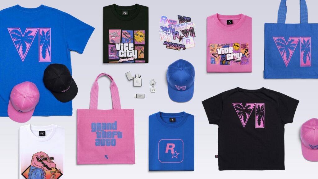 The Grand Theft Auto VI Collection laid out: VI logo tees in blue, pink and black, Vice City and Rockstar logo tees, pink and blue caps, totes, a Zippo lighter, money clip, keychain and sticker sheets. Image: Rockstar Games.