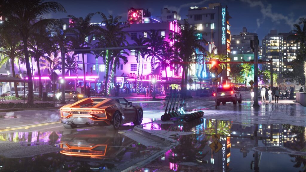 A rain-slicked neon strip at night: an orange sports car at a junction, a row of parked scooters, pink and blue neon on the Ocean View Hotel and the Hotel Dixon sign behind, reflected in the wet road. Image: Rockstar Games.